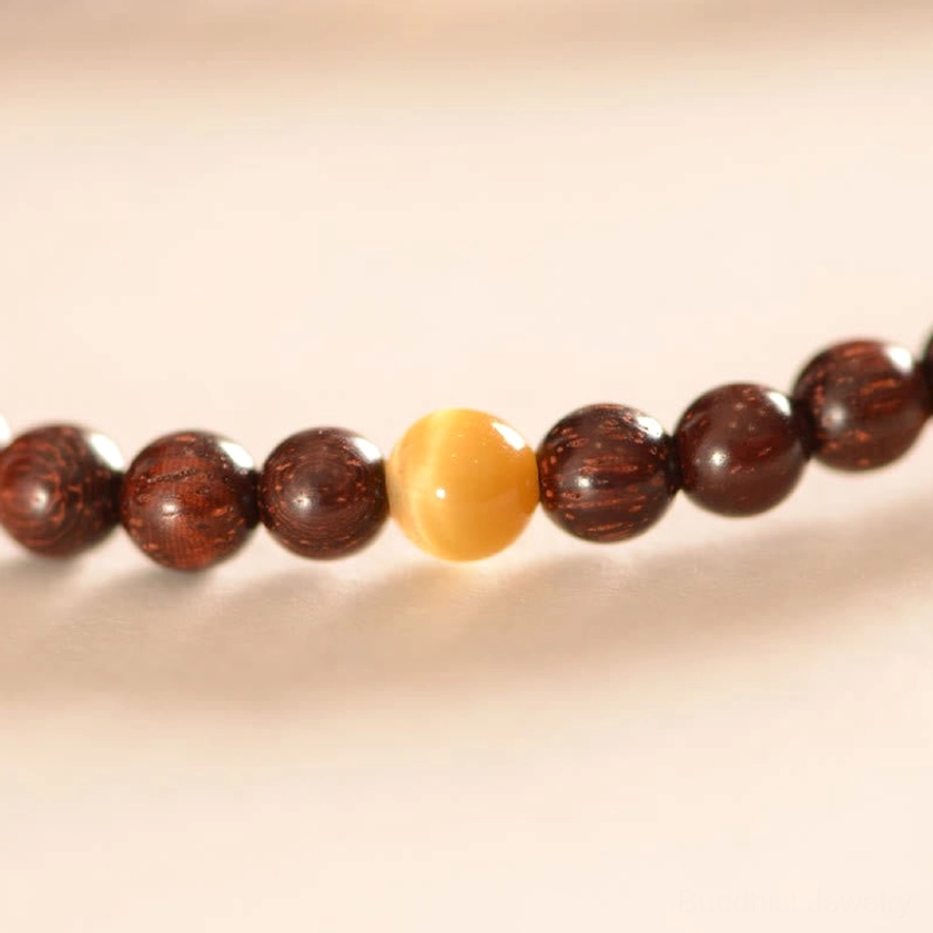 Macro photography of amber and decorative accent beads in red sandalwood Fu character bracelet