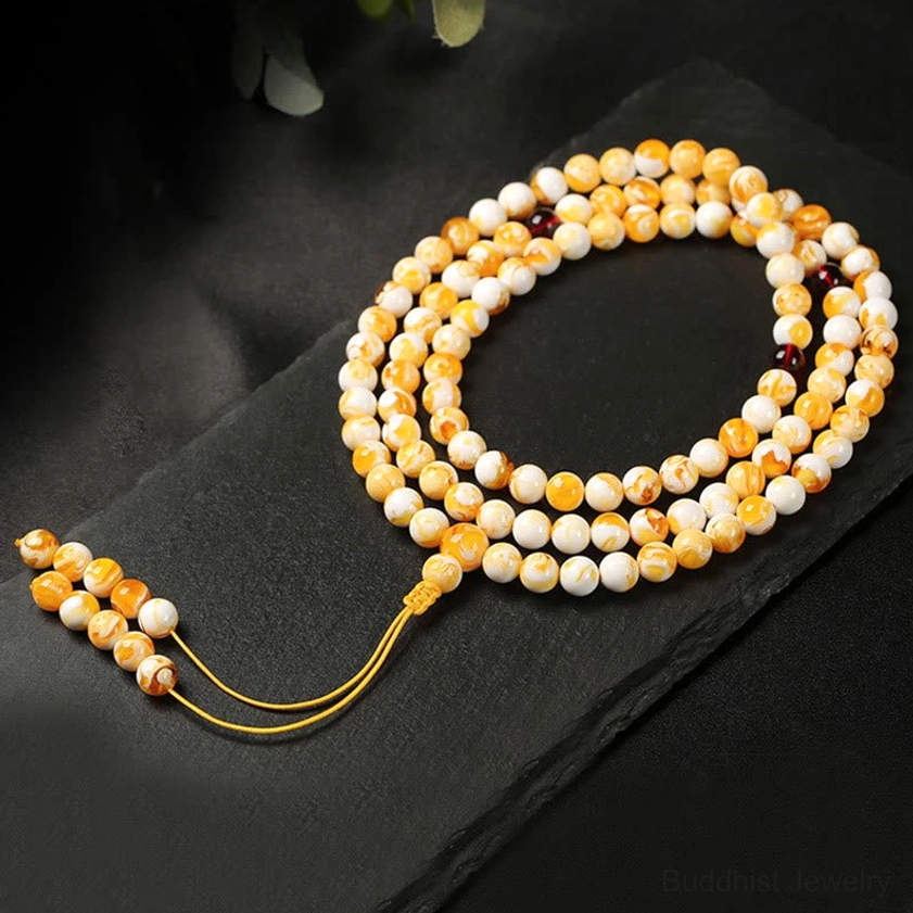 108 bead amber mala prayer beads flat lay gradient yellow off-white beads with yellow tassel