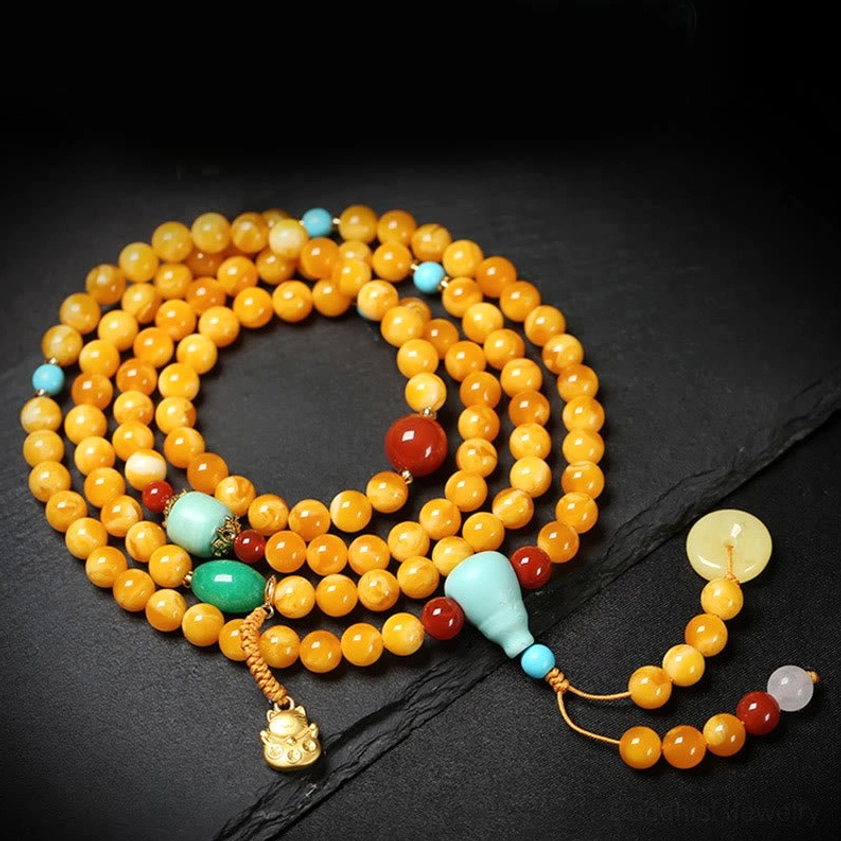 108 bead amber mala necklace loop showing jade peace buckle, gold lucky charm and mixed gemstone details