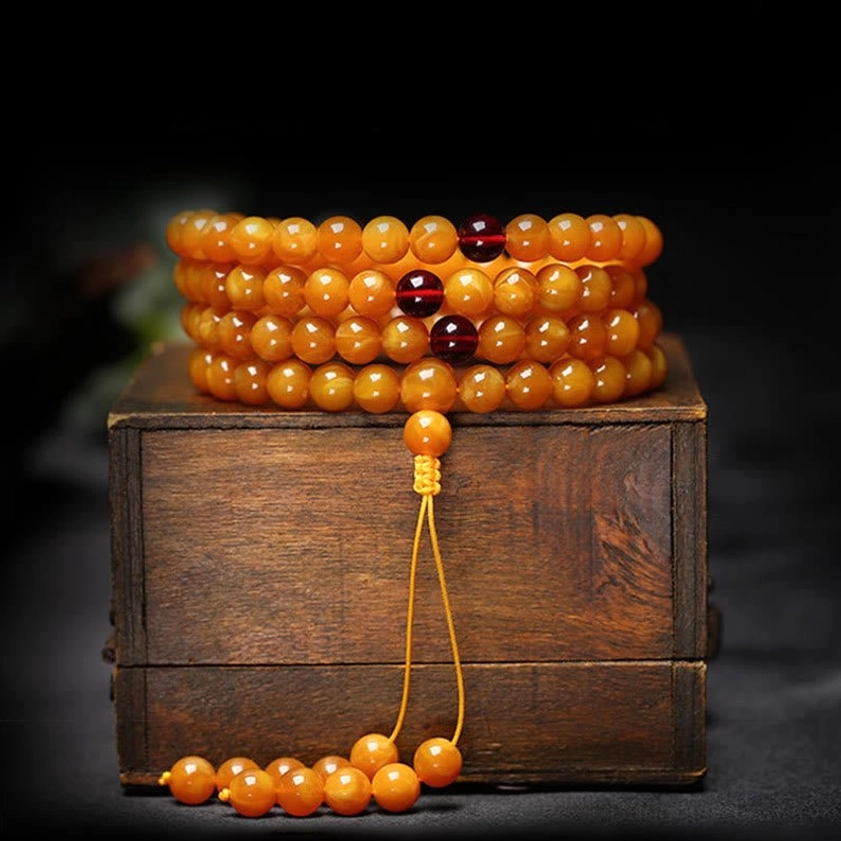 Layered amber Buddhist mala bracelet 108 beads with red spacers and long golden yellow tassel