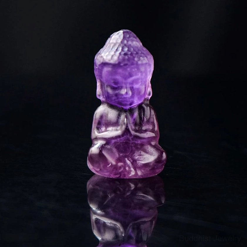 Amethyst carved baby Buddha ornament - front close-up of deep purple crystal Buddha in meditation pose
