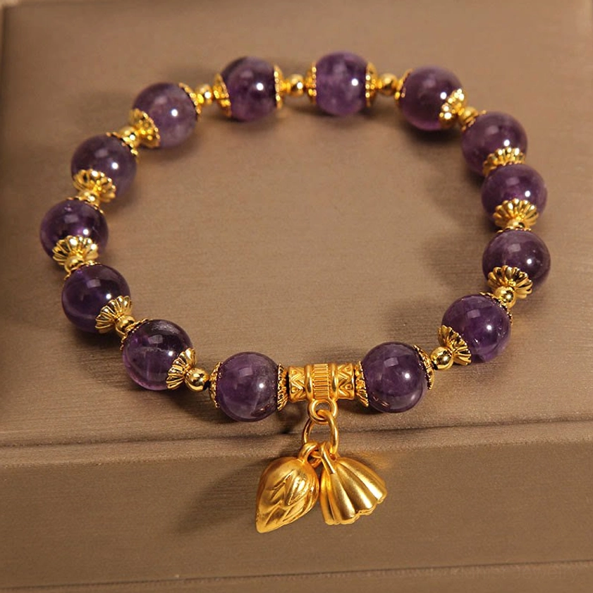 Amethyst lotus bracelet full view inside open jewelry box with polished stones and gold spacers