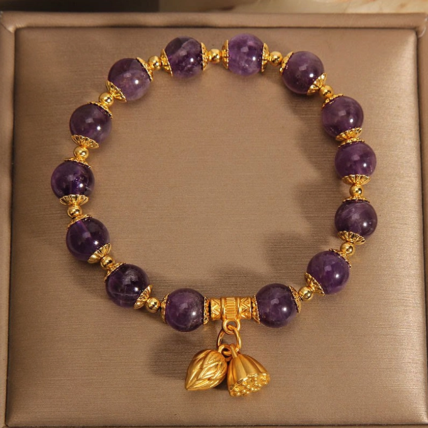 Amethyst lotus bracelet inside open jewelry box showing uniform purple beads with gold decorative rings