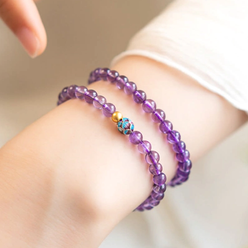 Multi-layer amethyst lotus bracelet set displayed overhead on wrist with white shirt sleeve