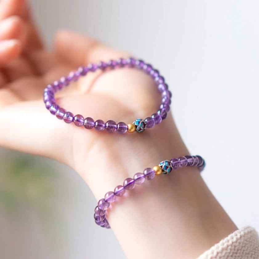 Two amethyst lotus bracelets worn together on wrist, showing layering style and matching spacer bead design