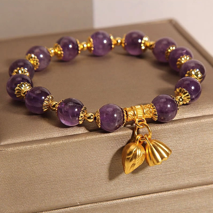 Amethyst lotus bracelet side view showing round purple beads with gold hardware and lotus charm details