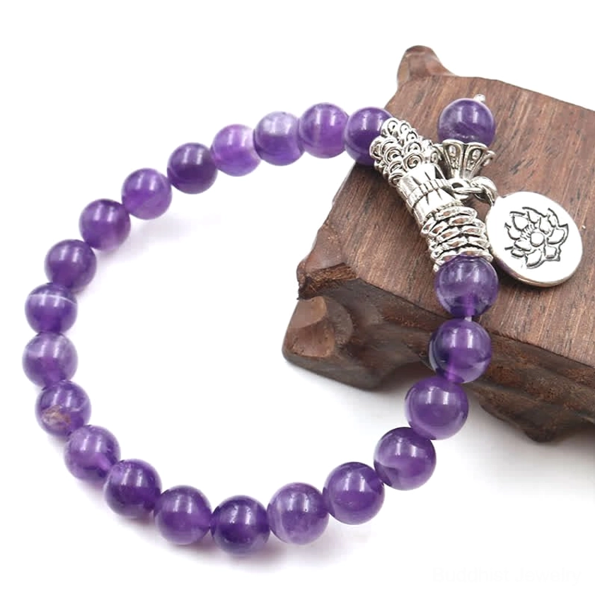 Amethyst crystal bracelet three-quarter view on wooden stand showing purple beads and twisted silver accents with lotus pendant
