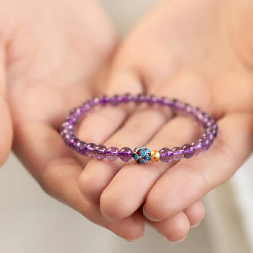 Amethyst lotus bracelet held in hands, showing wearable fit and round purple crystal bead quality