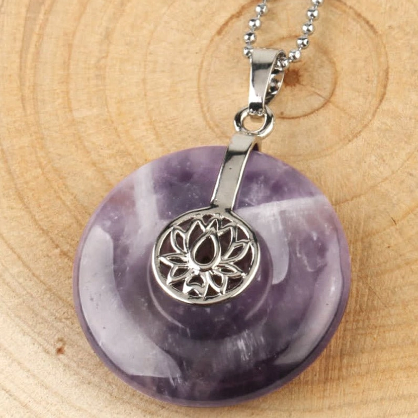 Amethyst lotus crystal healing pendant - close-up front view on wood grain background