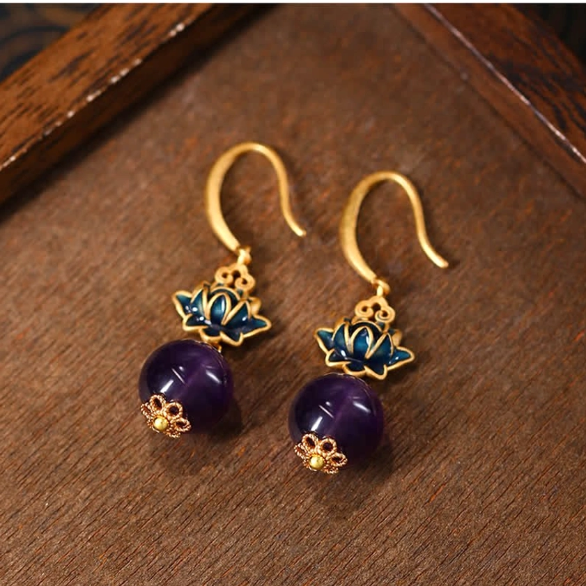 Amethyst lotus drop earrings flat lay showing gold-plated hardware and blue enamel lotus charm with purple amethyst bead