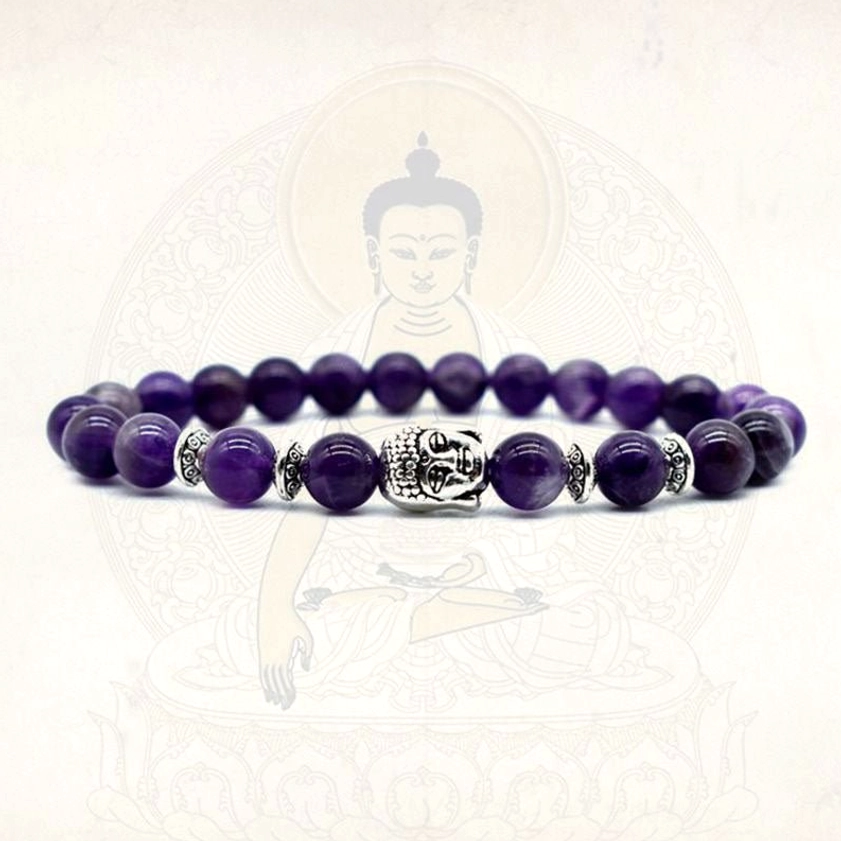 Buddhist healing bracelet with amethyst and tiger eye stones and silver Buddha charms on spiritual background