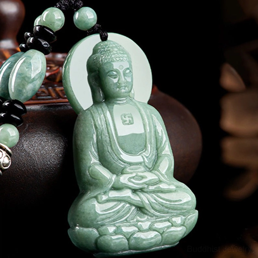 Amitabha Buddha jade necklace three-quarter view with mixed green and black beaded chain on dark brown vessel, showing silver metal clasp