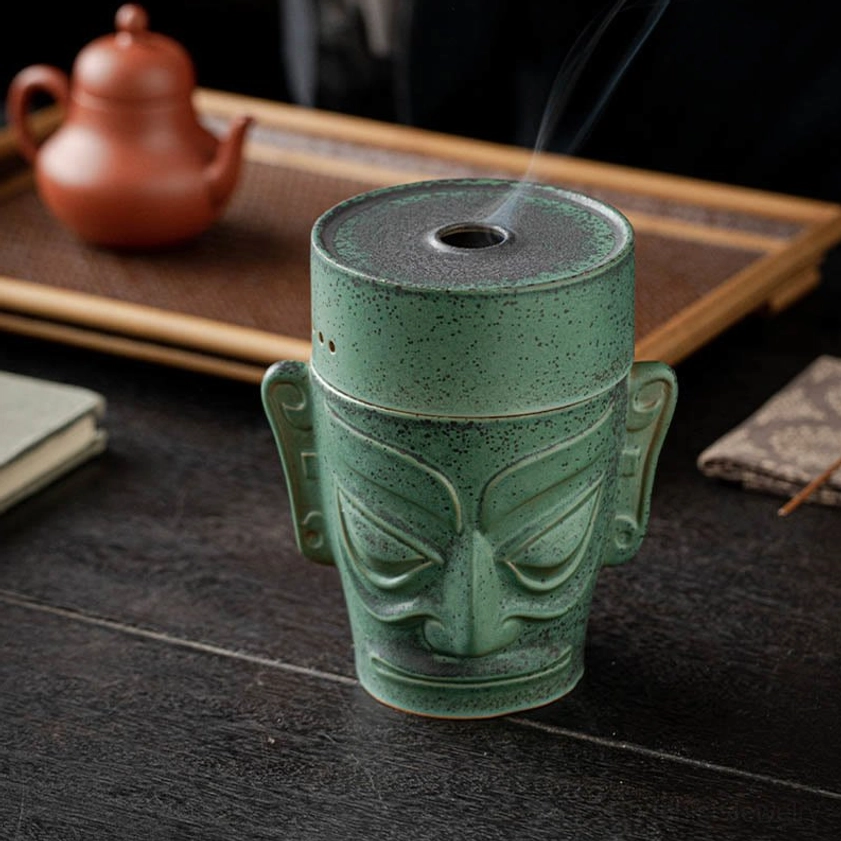 Front three-quarter angle of handcrafted incense burner showing central smoke vent on lid, speckled green glaze finish