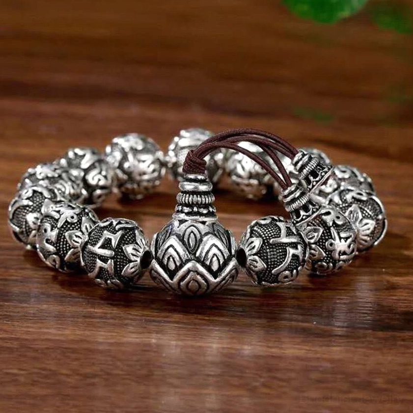 Antique silver mala bracelet featuring large lotus-carved guru bead with full mantra engravings on dark cord