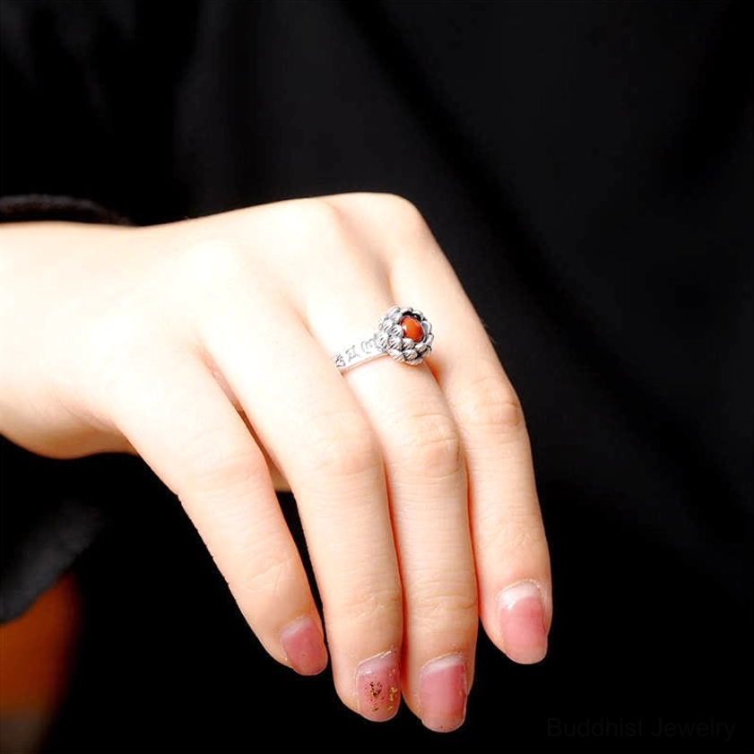 Vintage sterling silver lotus red agate ring side view worn on hand against pure black background