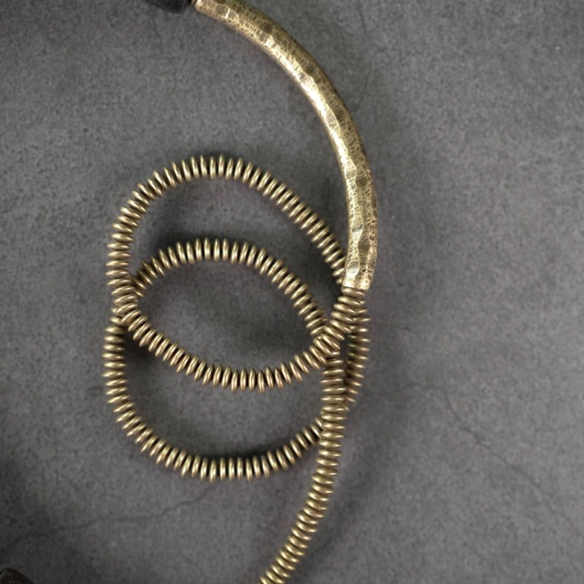 Detailed close-up of vintage antiqued copper spiral coil beads with ridged texture