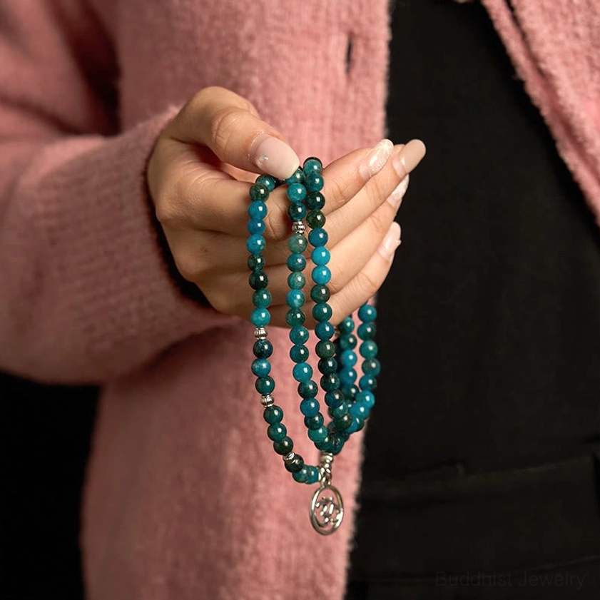 Blue apatite prayer mala bracelet close-up hand-held view with multi-strand beaded design and silver drop charm