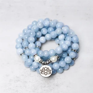 108 aquamarine mala bead bracelet overhead view with silver lotus charm on light background