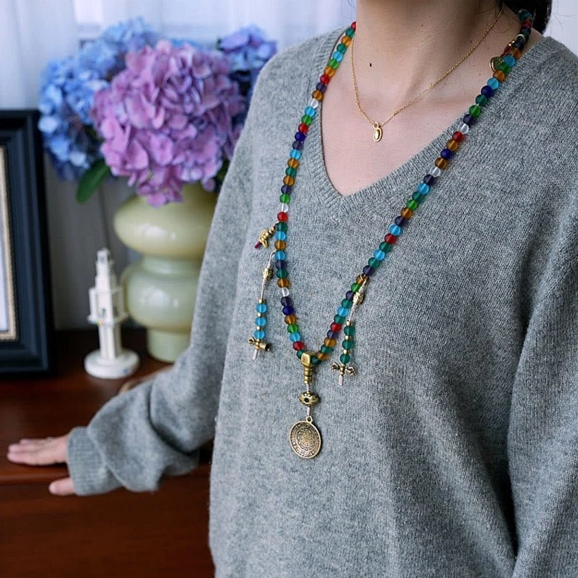 Artisan handcrafted 108-bead mala in Liuli glass with copper brass charms, authentic Buddhist prayer jewelry detail