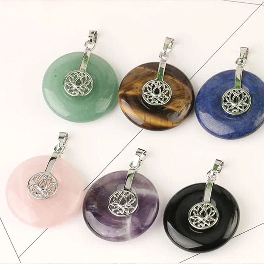 Assorted multi-chakra lotus crystal pendants - top-down flat lay showing variety of gemstones
