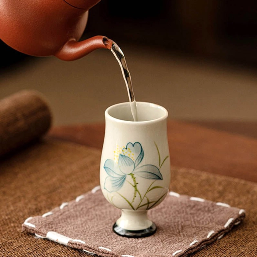 Authentic hand-painted lotus tea cup showing traditional ceramic craftsmanship and Buddhist cultural artistry