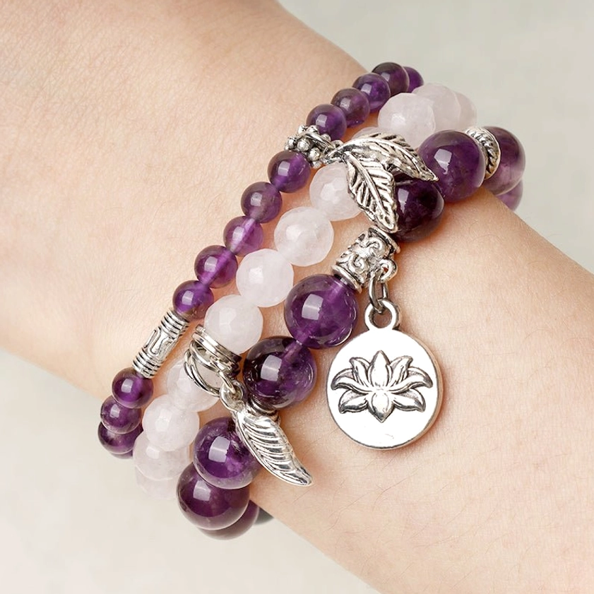 Natural crystal healing bracelet on real human wrist featuring mixed gemstone beads with silver lotus and leaf charm pendants
