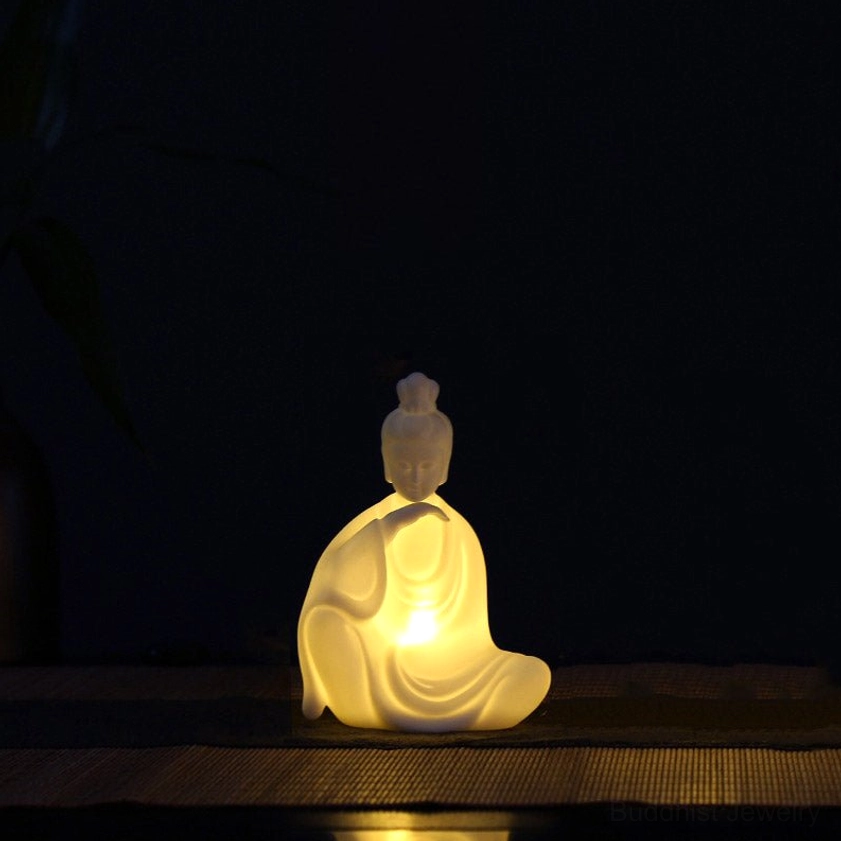 Avalokitesvara Bodhisattva ceramic LED statue with warm glowing light, compassion mudra, sacred Buddhist iconography