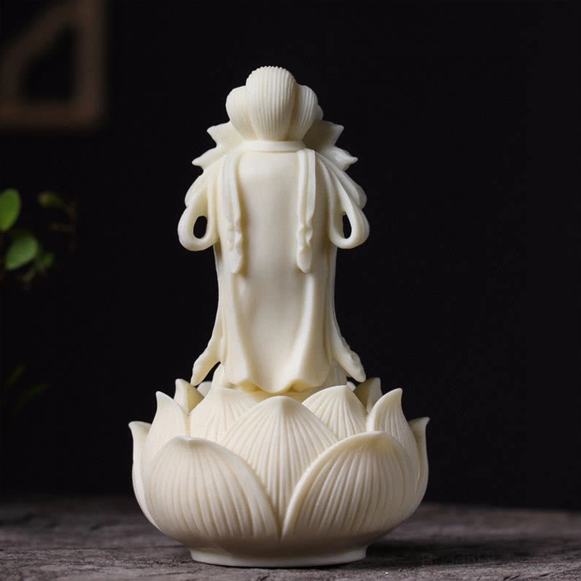 Rear view of hand-carved Guanyin Buddha figure with detailed lotus petal base texture and cream-white natural finish