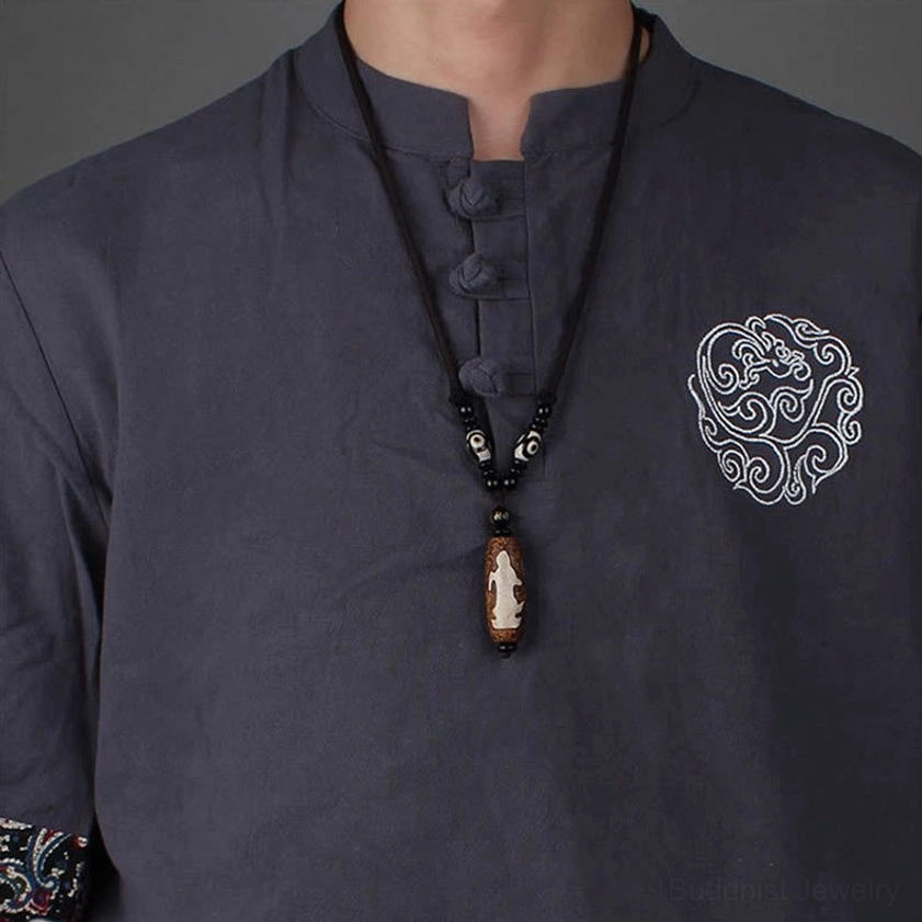 Male model wearing Avalokitesvara Buddhist Dzi bead necklace with traditional style clothing and braided cord