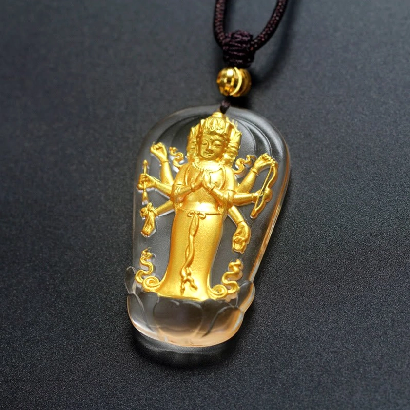 Intricate multi-armed Guanyin Buddha statue inside clear Liuli crystal casing with polished gold plating detail angled close-up