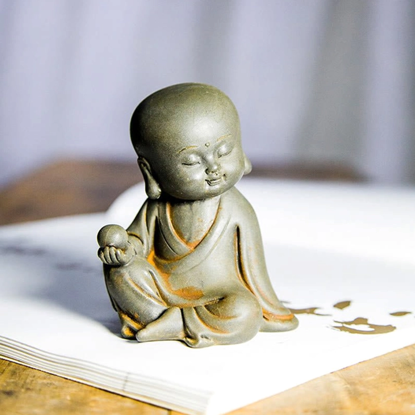 Avalokitesvara Guanyin bodhisattva meditation statue rust finish three-quarter view with book backdrop