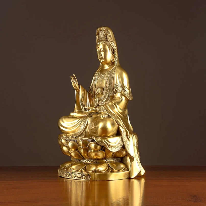 Avalokitesvara Guanyin statue left three-quarter angle view, warm golden brass tone, intricate robe carvings, sacred seated pose