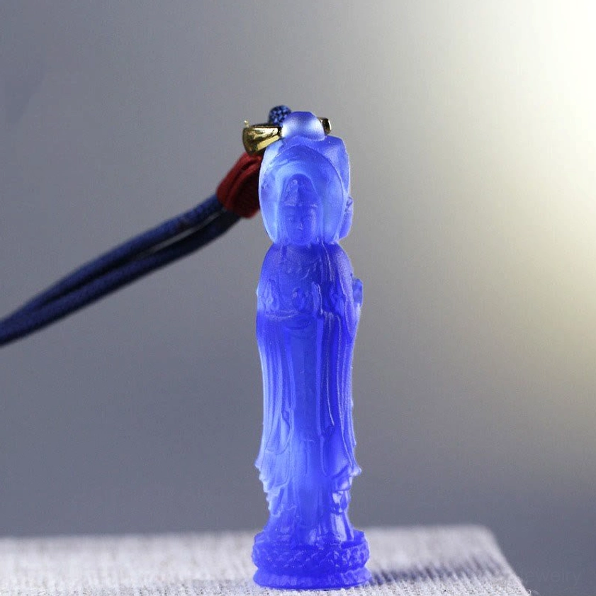 Deep blue translucent Avalokitesvara Liuli glass pendant with dark blue braided cord and red knot, front view