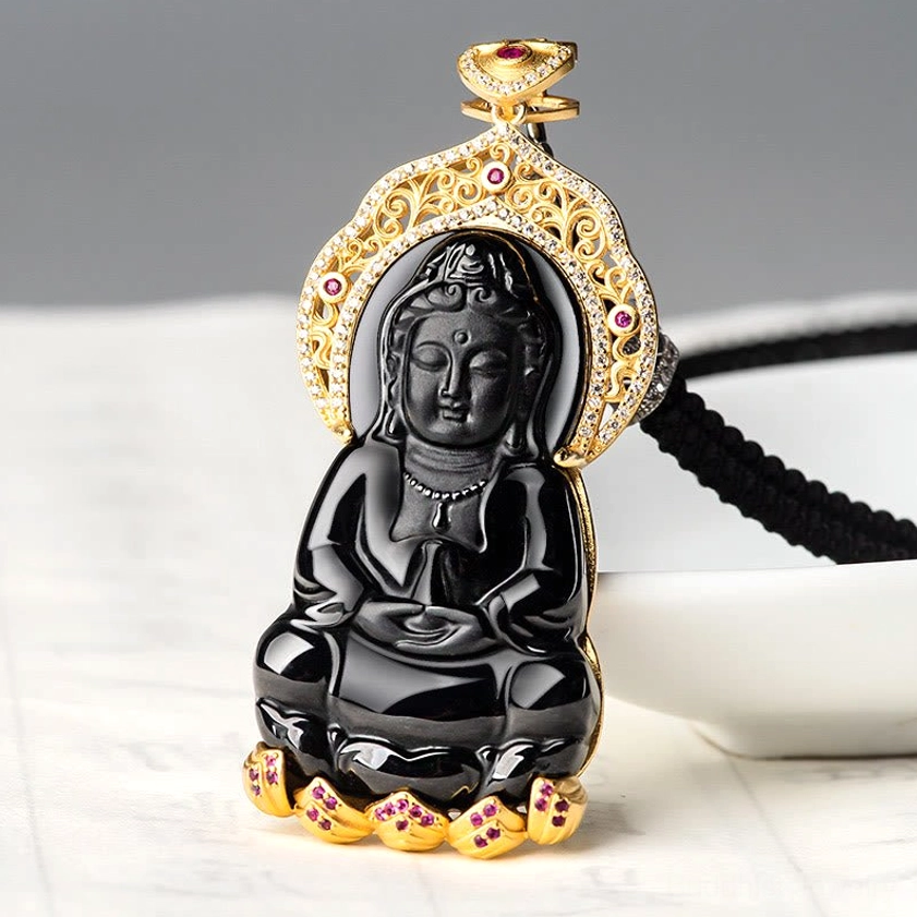 Black jade Guanyin necklace pendant with titanium steel chain displayed on tabletop with ceramic bowl, showing complete necklace set
