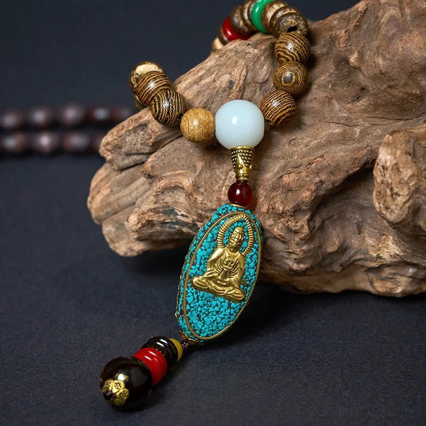 Close-up side view of Avalokitesvara pendant necklace showing wooden bead details and turquoise Buddha charm with tassel