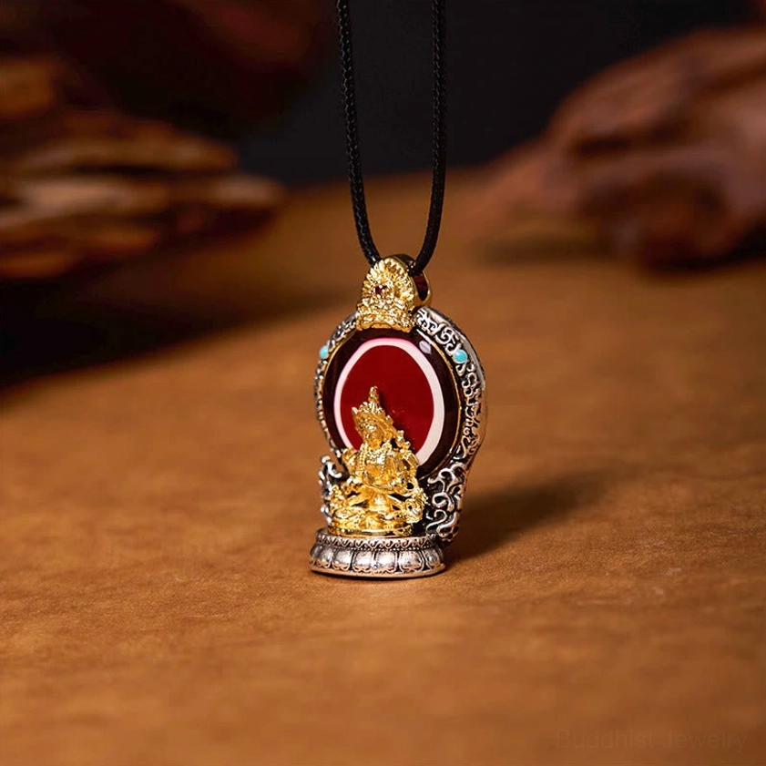 Three-quarter view of handcrafted Avalokitesvara amulet pendant showing intricate gold plated deity figure and silver carved frame detail