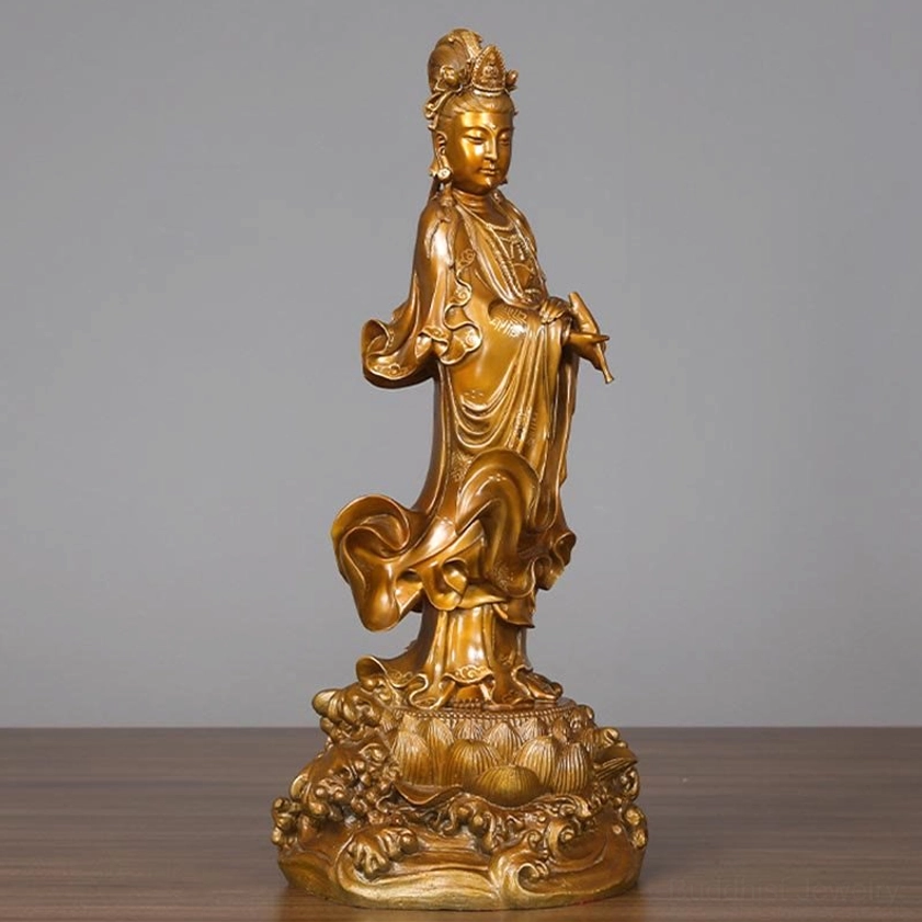 Avalokitesvara brass statue featuring golden bronze finish and flowing robes on decorative lotus-wave base, left front angle