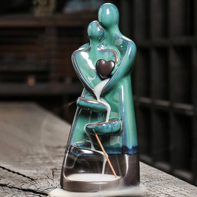 Glossy turquoise ceramic backflow burner with incense stick and white smoke flow