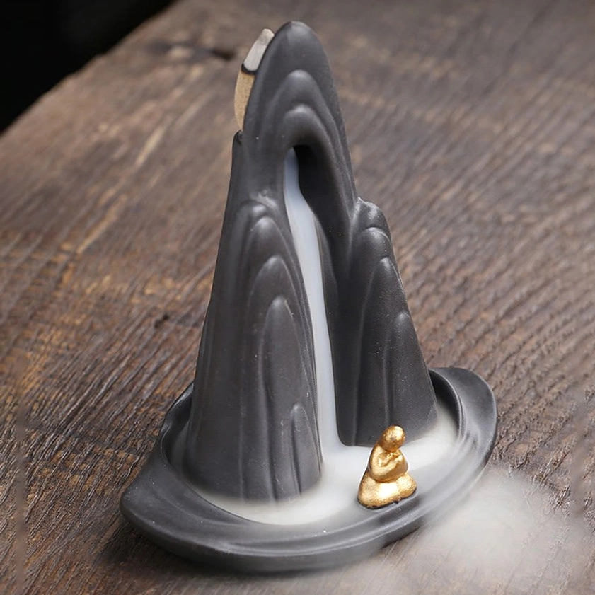 Purple clay backflow incense burner with monk figurine and cascading smoke waterfall effect