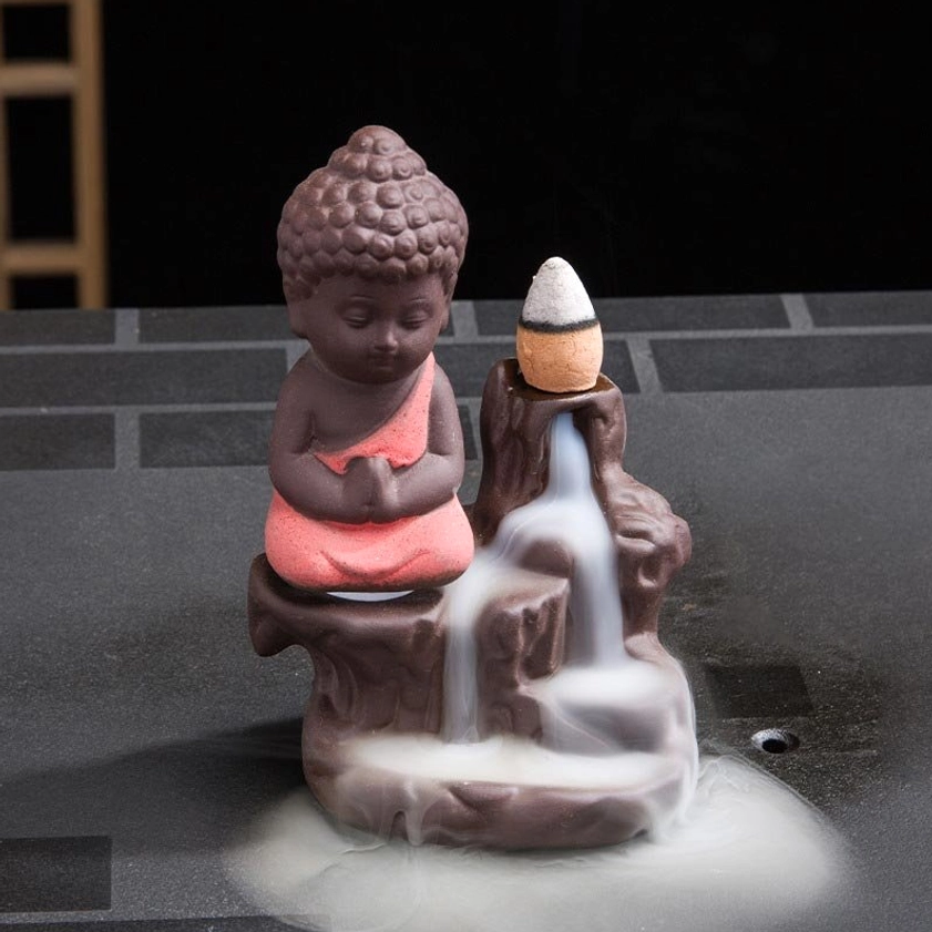 Right side perspective of backflow incense burner with monk figure and flowing white smoke down rock structure