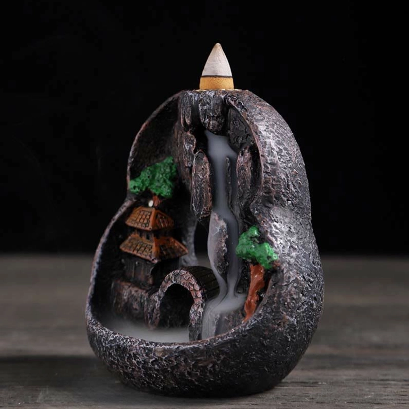 Side view of scenic backflow incense holder with miniature mountain landscape and cascading smoke