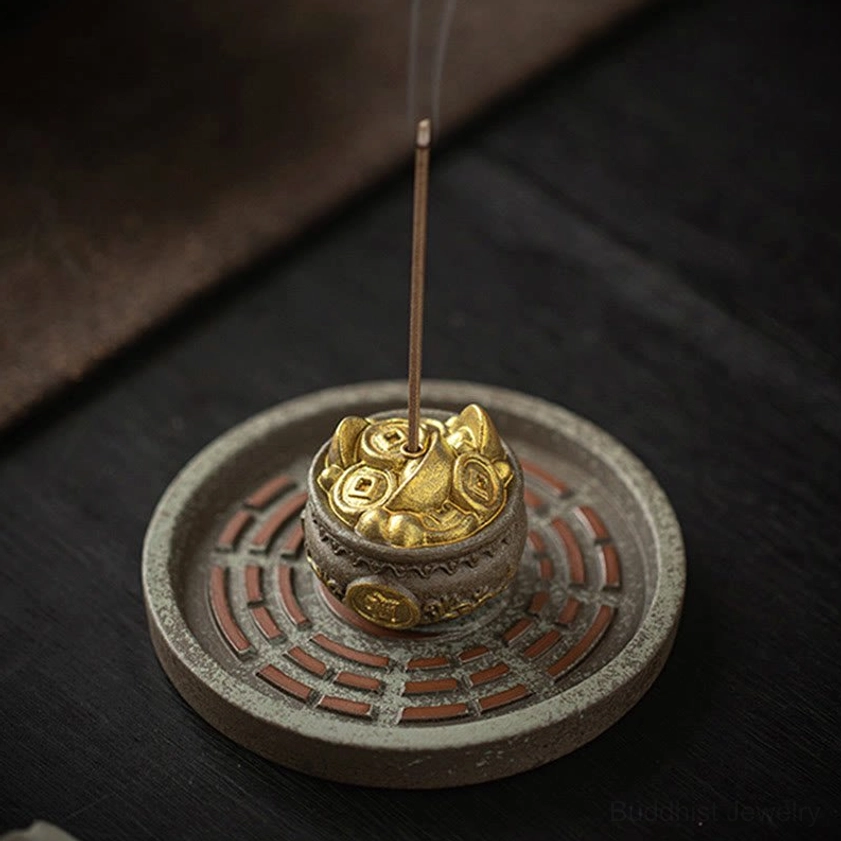 Side high-angle view of red engraved Bagua tray incense burner with vintage brown ceramic and gold coin accents