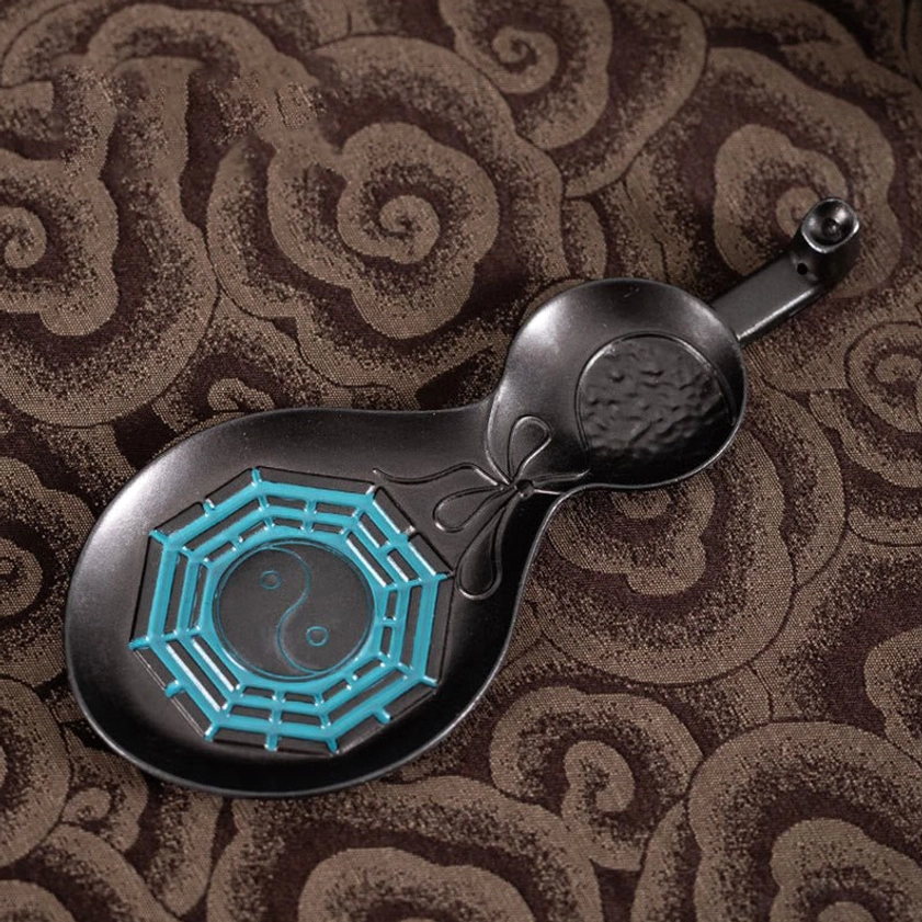Close-up of Yin Yang Bagua incense holder showing intricate bowknot embossed design with cyan decorative patterns