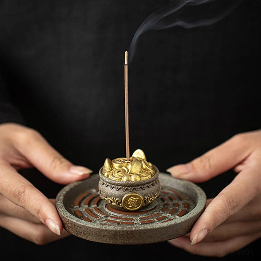Front view of Bagua incense burner held in hands with smoking incense stick and round Bagua tray design