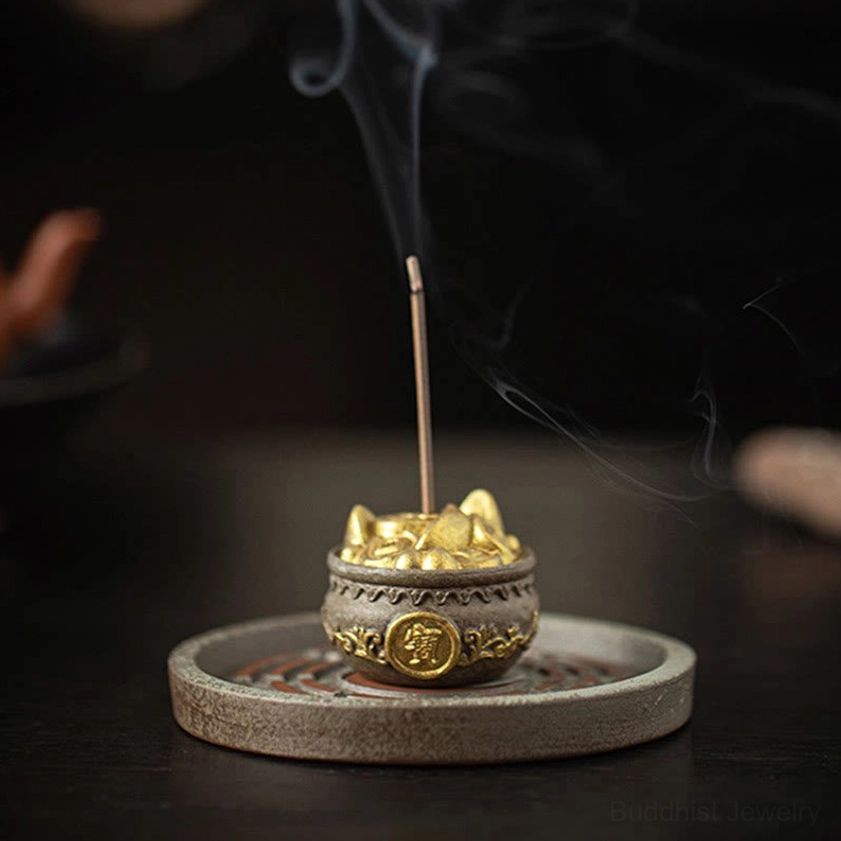 High-angle side view of oval Bagua tray incense burner with embossed gold coin bowl and wispy smoking incense