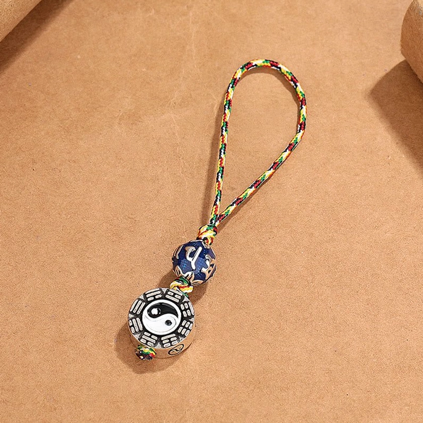 Buddhist charm keychain showing detailed Bagua and Yin Yang pendant with vibrant woven lanyard and spiritual bead, right side angle