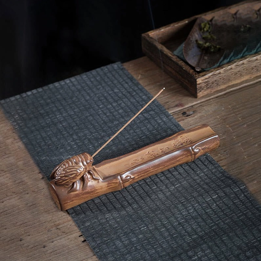 Bamboo cicada incense burner with brown glazed ceramic, bamboo base, and cicada ornament on wooden table