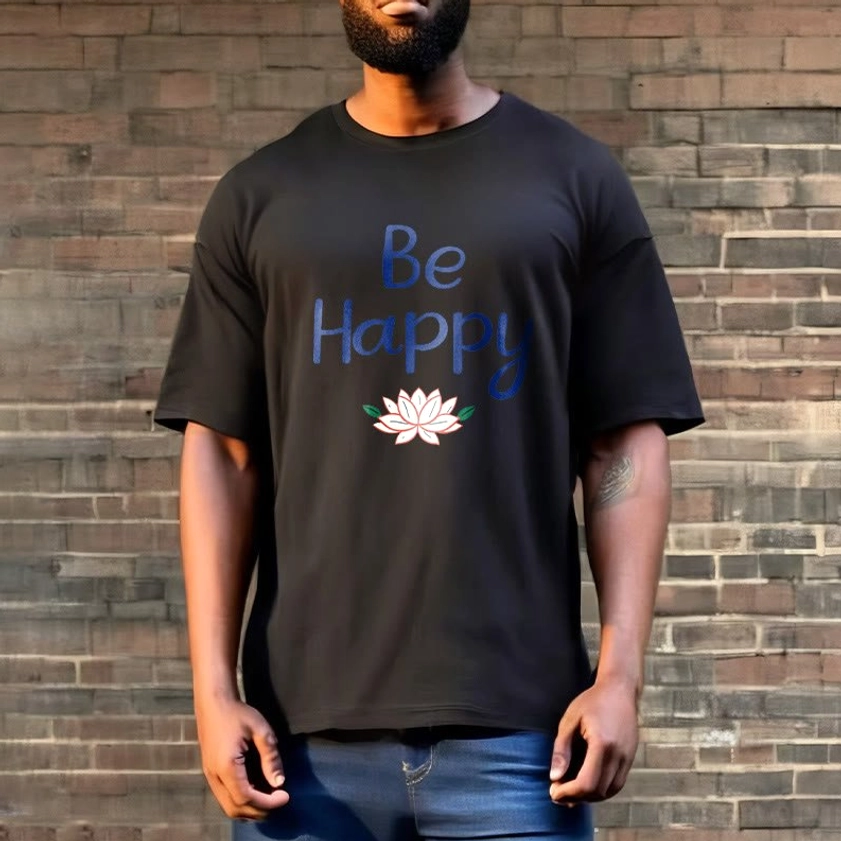 Male model wearing black Be Happy lotus tee outdoors, paired with blue jeans, brick wall background