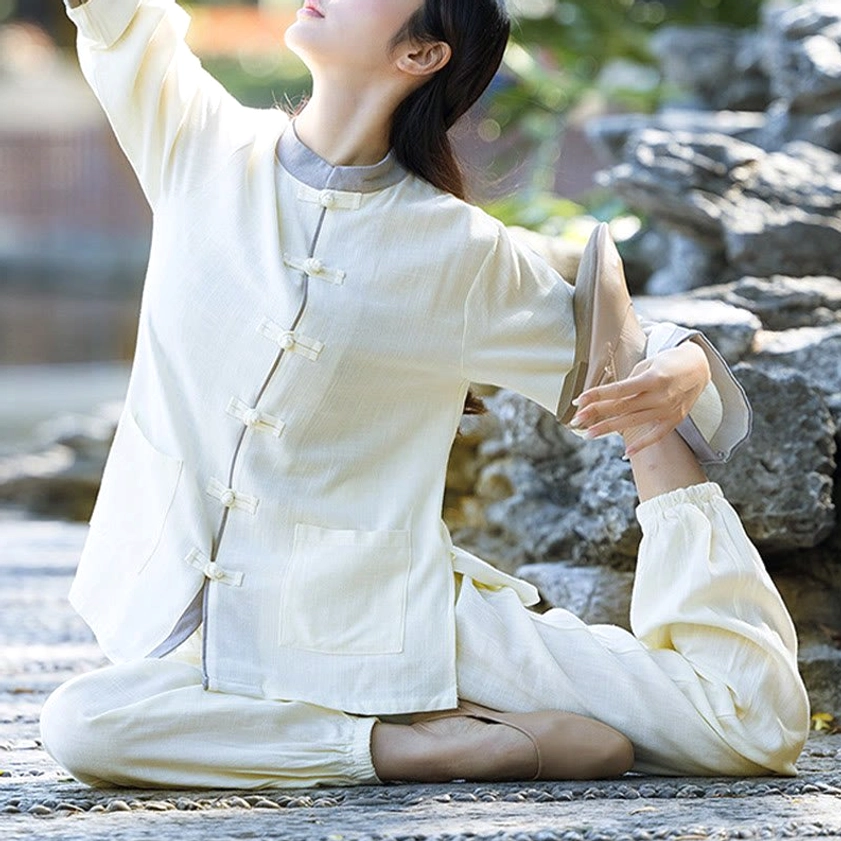Cotton linen tai chi suit in beige, three-quarter view with woman performing leg stretch by water