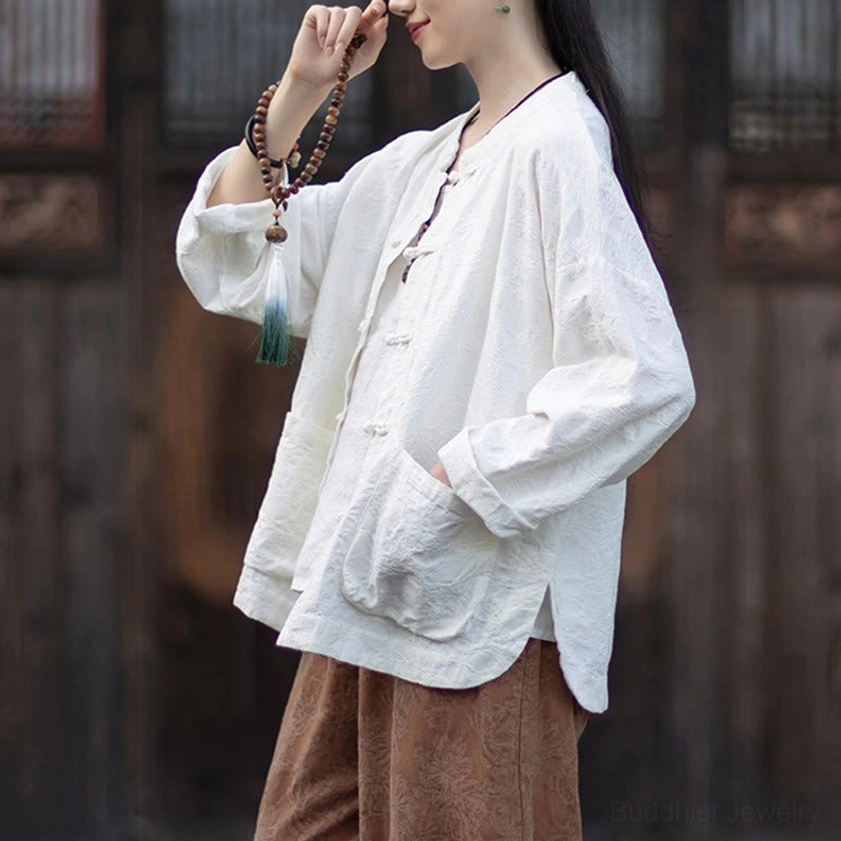 Detail of stand collar and frog button closures on beige jacquard meditation shirt